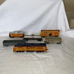 5 Train Cars & One Lifelike Diesel Engine Light Works Ho Scale. Fixed Price $45.00.